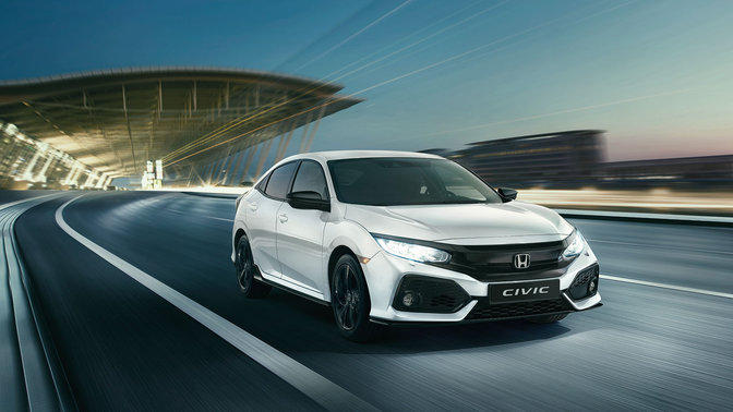 Vue de trois quarts avant de la Honda Civic Dynamic, roulant dans un paysage urbain.