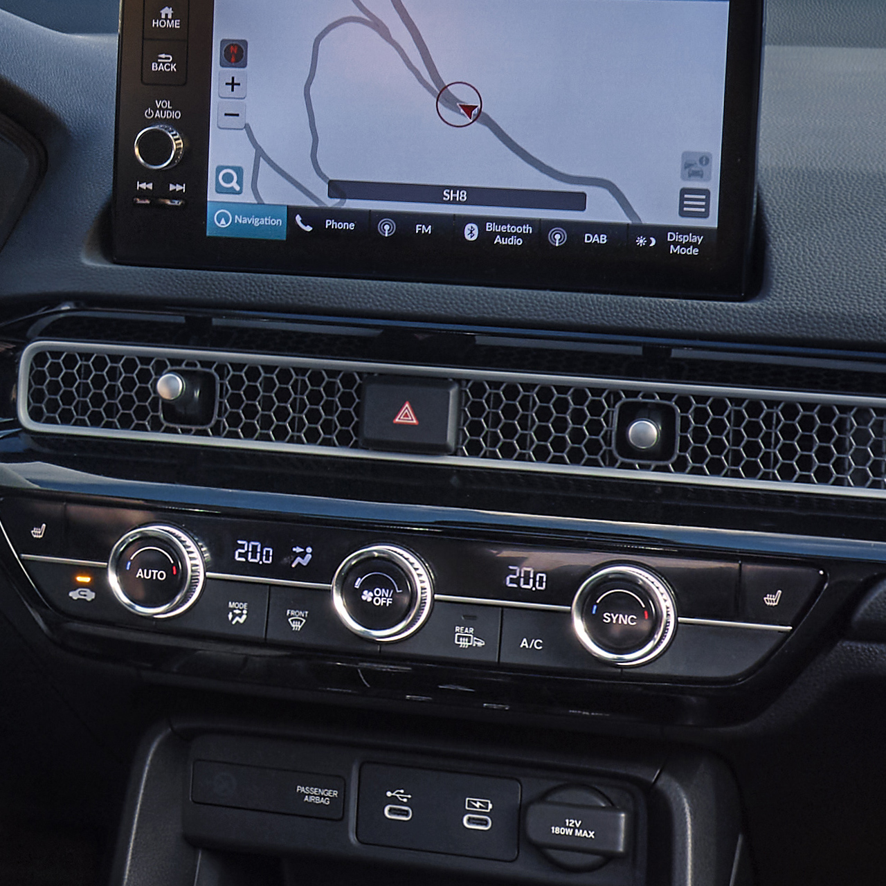 Photo prise depuis l'intérieur de la Civic Hybrid, un homme conduisant sur une route panoramique.