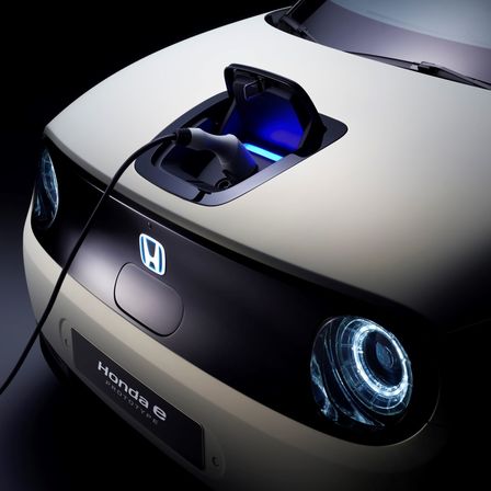 Vue de trois-quarts avant de la Honda Urban EV Concept avec borne de charge.