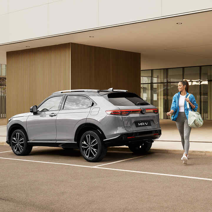 Femme passant devant un HR-V en stationnement. 