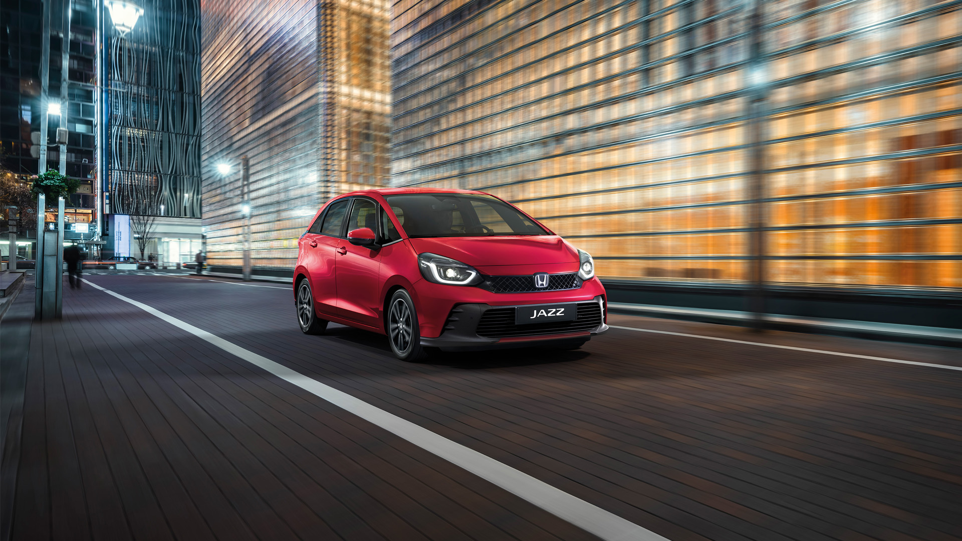 Honda Jazz trois quarts avant devant un paysage urbain.