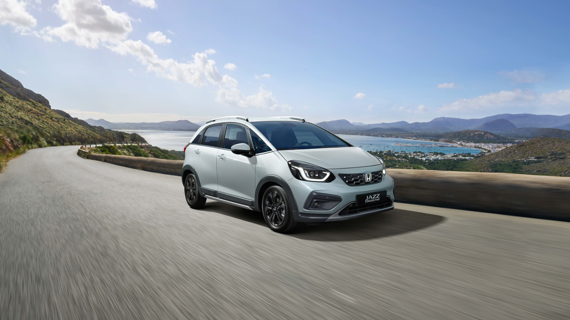 Vue de face 3/4 de la Honda Jazz Hybrid conduite sur une route de montagne.