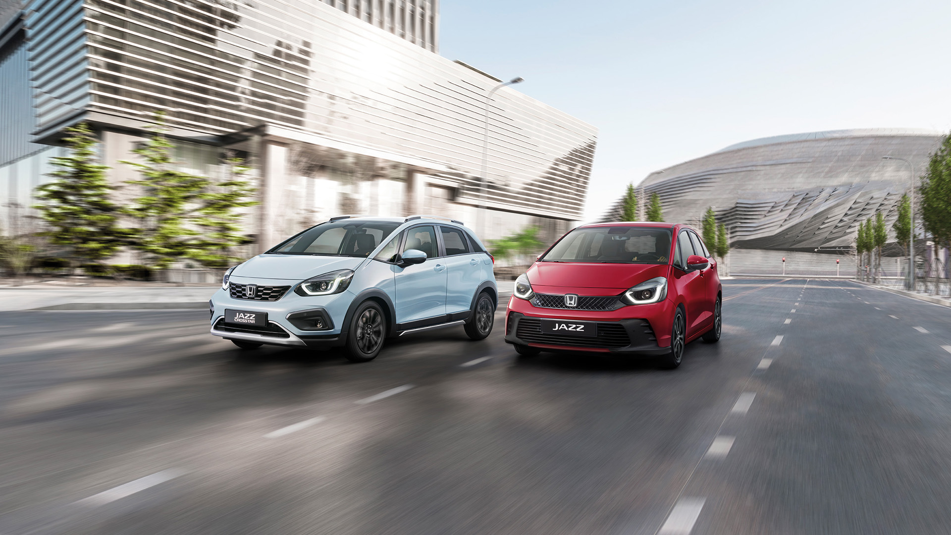 Une Honda Jazz Hybride et une Honda Jazz Crosstar roulent côte à côte en ville.