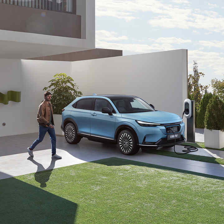 Une femme branchant un CR-V 2024 à domicile.