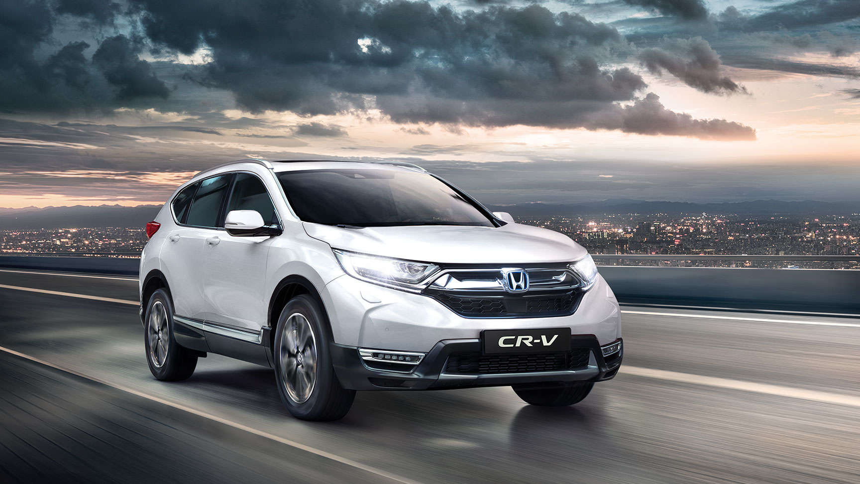 Vue de trois-quarts avant de la Honda CR-V avec les feux de route allumés